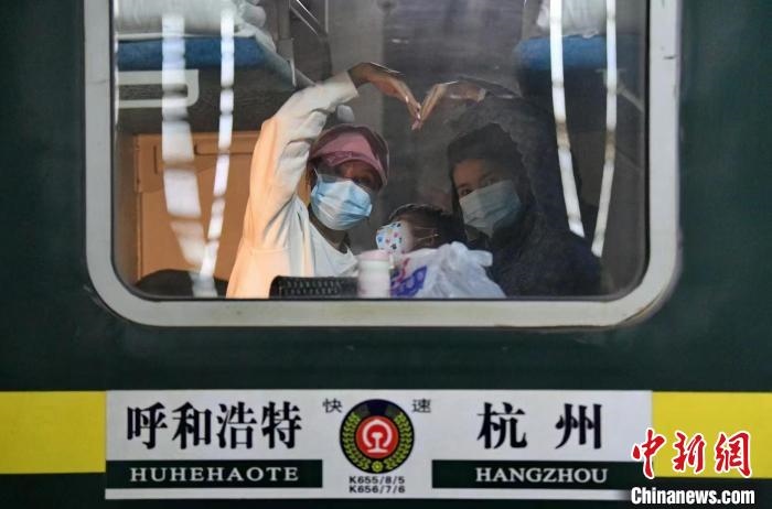 圖為登上轉(zhuǎn)運(yùn)火車(chē)的游客向額濟(jì)納比心?！⊥趵?攝