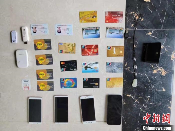 資料圖為果洛藏族自治州公安民警查扣的作案手機(jī)和涉案銀行卡?！‖斍呖h公安局供圖