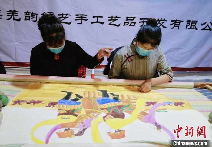 圖為皮繡藝人在市集上“秀”指尖技藝。　馬銘言 攝