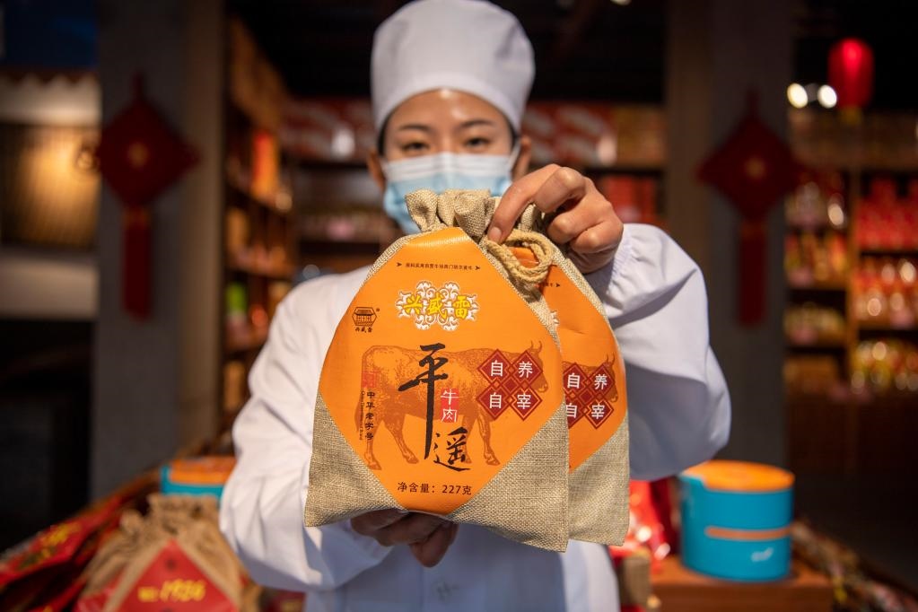 1月27日，在平遙古城南大街的一家平遙牛肉店內(nèi)，工作人員展示一款牛肉產(chǎn)品。新華社記者 楊晨光 攝