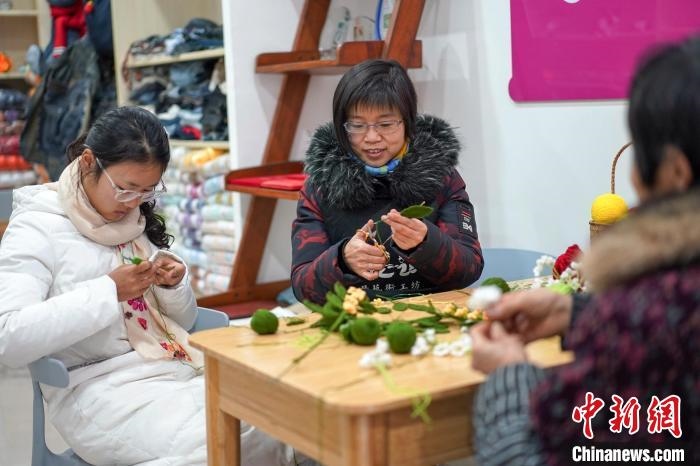 文創(chuàng)工作室的姐妹們正在鉤織月桂葉片。　古良駒 攝