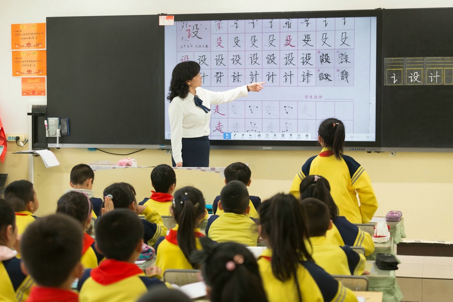 民族路小學(xué)（迎賓校區(qū)），語文老師燕凌云與學(xué)生們共同評(píng)議同學(xué)書寫的漢字.jpg