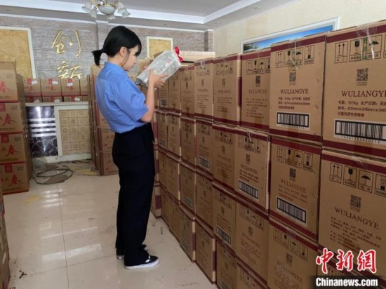 資料圖為檢察人員核對(duì)查獲的假冒品牌白酒。青海省人民檢察院供圖