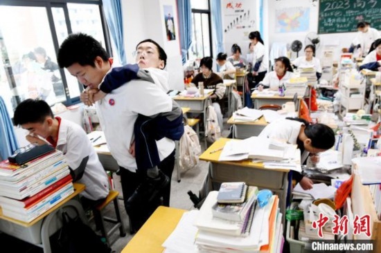 遇到鐘華強課堂上內急，江西省南康中學北校區(qū)的高三學生朱金祥便會及時背著他前往衛(wèi)生間。 卓忠偉 攝