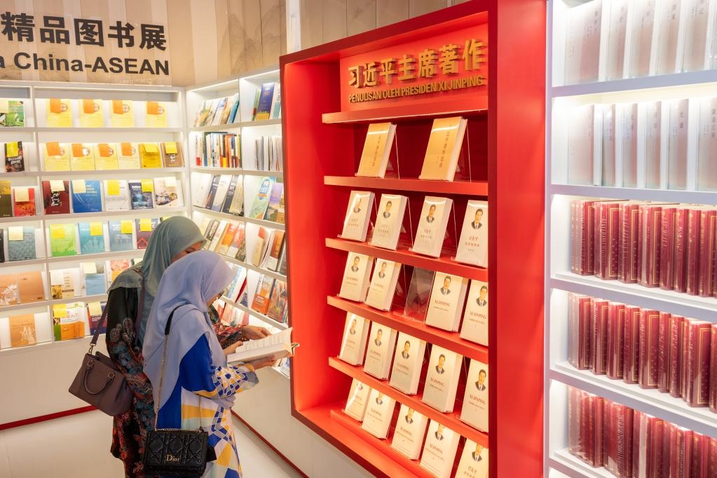 5月30日，兩名讀者在馬來(lái)西亞吉隆坡國(guó)際書(shū)展中國(guó)主賓國(guó)活動(dòng)現(xiàn)場(chǎng)閱讀習(xí)近平主席著作。新華社記者朱煒攝