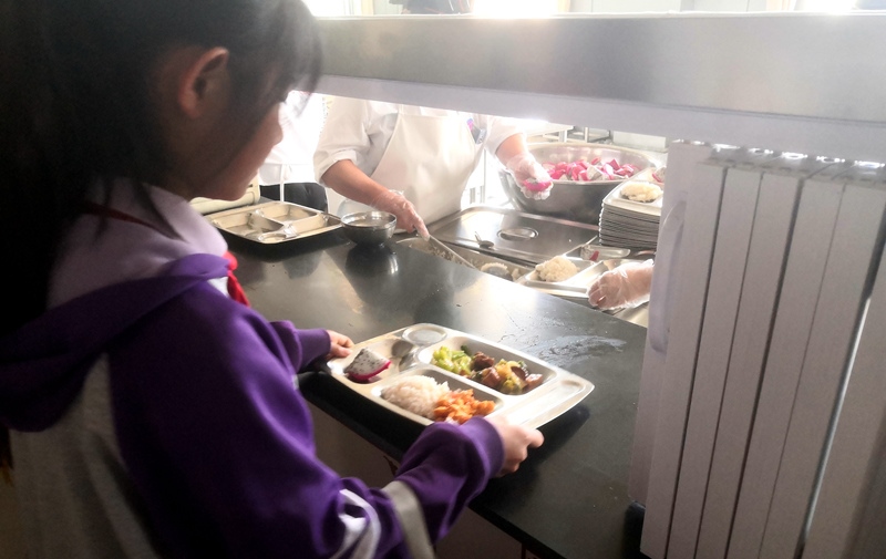 伊金霍洛旗第一小學(xué)學(xué)生正在打飯，今天的飯菜是三菜一湯外加水果，學(xué)生可以多次盛取，吃飽為止。人民網(wǎng)記者 孫博洋攝