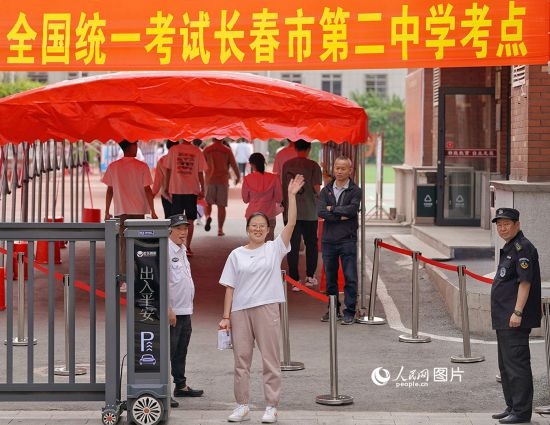 6月7日，在長春市第二中學(xué)考點，一名考生信心滿滿進(jìn)入考場，并與家長揮手致意。人民網(wǎng)記者 李洋攝