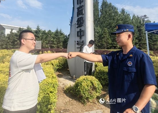 6月7日，遼寧營口老邊區(qū)消防救援大隊的消防員為高考學(xué)子加油助威。人民網(wǎng)記者 尹柏寒?dāng)z