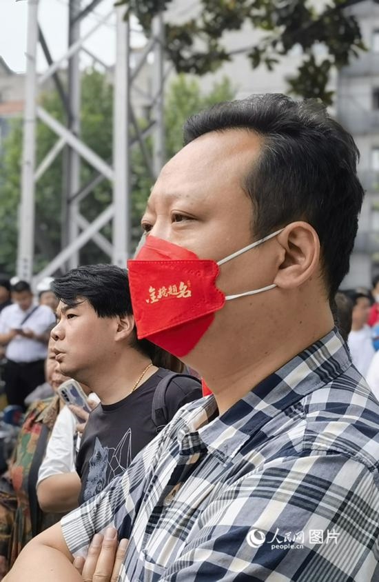 6月7日早，在武漢市第二十六中學(xué)考點外，送考家長戴著印有“金榜題名”的口罩。人民網(wǎng) 周雯攝