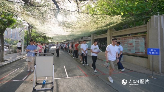 6月7日，烏魯木齊市第七十中學(xué)門口，考生們有序進(jìn)入考場。人民網(wǎng) 李欣洋攝