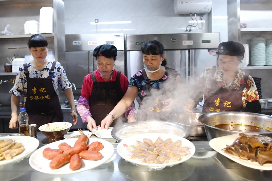 福建三明市沙縣區(qū)一家小吃店工作人員在為客人準(zhǔn)備特色小吃。 新華社記者 林善傳 攝