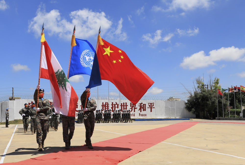 在黎巴嫩南部辛尼亞村的中國維和部隊營區(qū)，中國維和部隊官兵在受勛后通過觀禮臺（2022年7月1日攝）。聯(lián)合國駐黎巴嫩臨時部隊（聯(lián)黎部隊）當(dāng)日授予中國第20批赴黎巴嫩維和部隊全體410名官兵聯(lián)合國“和平勛章”，以表彰他們?yōu)槔璋湍勰喜康貐^(qū)和平穩(wěn)定作出的突出貢獻(xiàn)。新華社記者 劉宗亞 攝
