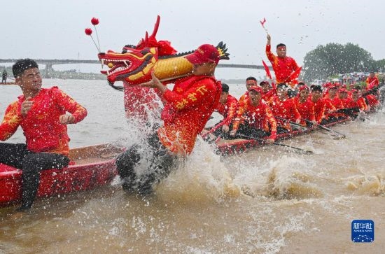 6月22日，在湖南省岳陽市湘陰縣湘江臨資口水域，參加龍舟賽的隊員接“龍頭”下水。