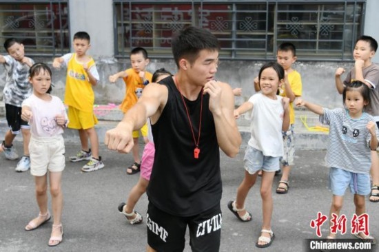 圖為大學(xué)生志愿者在組織孩子們參加體育健身活動(dòng)。廖光福 攝