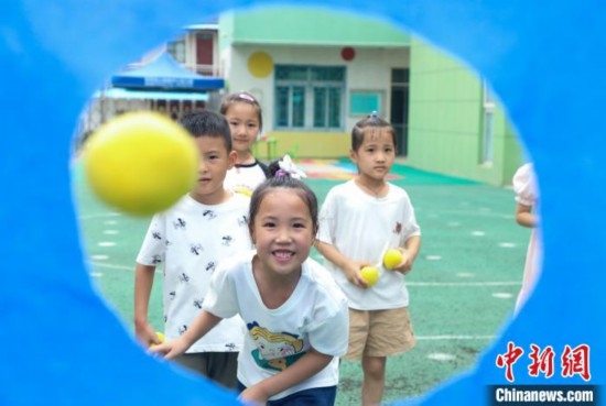 在肥西縣山南鎮(zhèn)中心幼兒園，孩子們在玩布洞投球游戲。陳家樂 攝