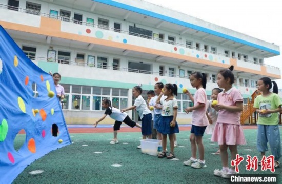 在肥西縣山南鎮(zhèn)中心幼兒園，孩子們在玩布洞投球游戲。陳家樂 攝