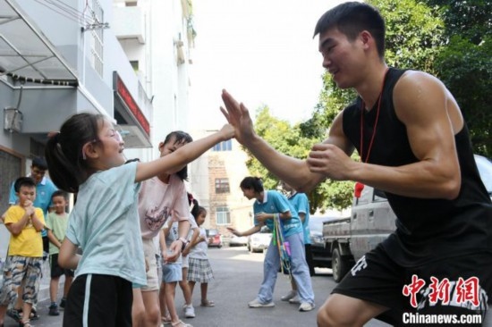圖為大學(xué)生志愿者在組織孩子們參加體育健身活動(dòng)。廖光福 攝
