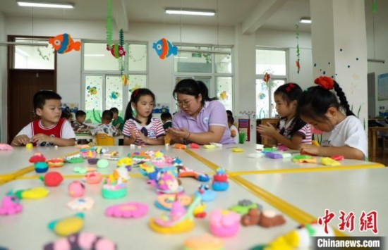 在肥西縣山南鎮(zhèn)中心幼兒園，孩子們在老師的指導下做彩色泥塑。陳家樂 攝