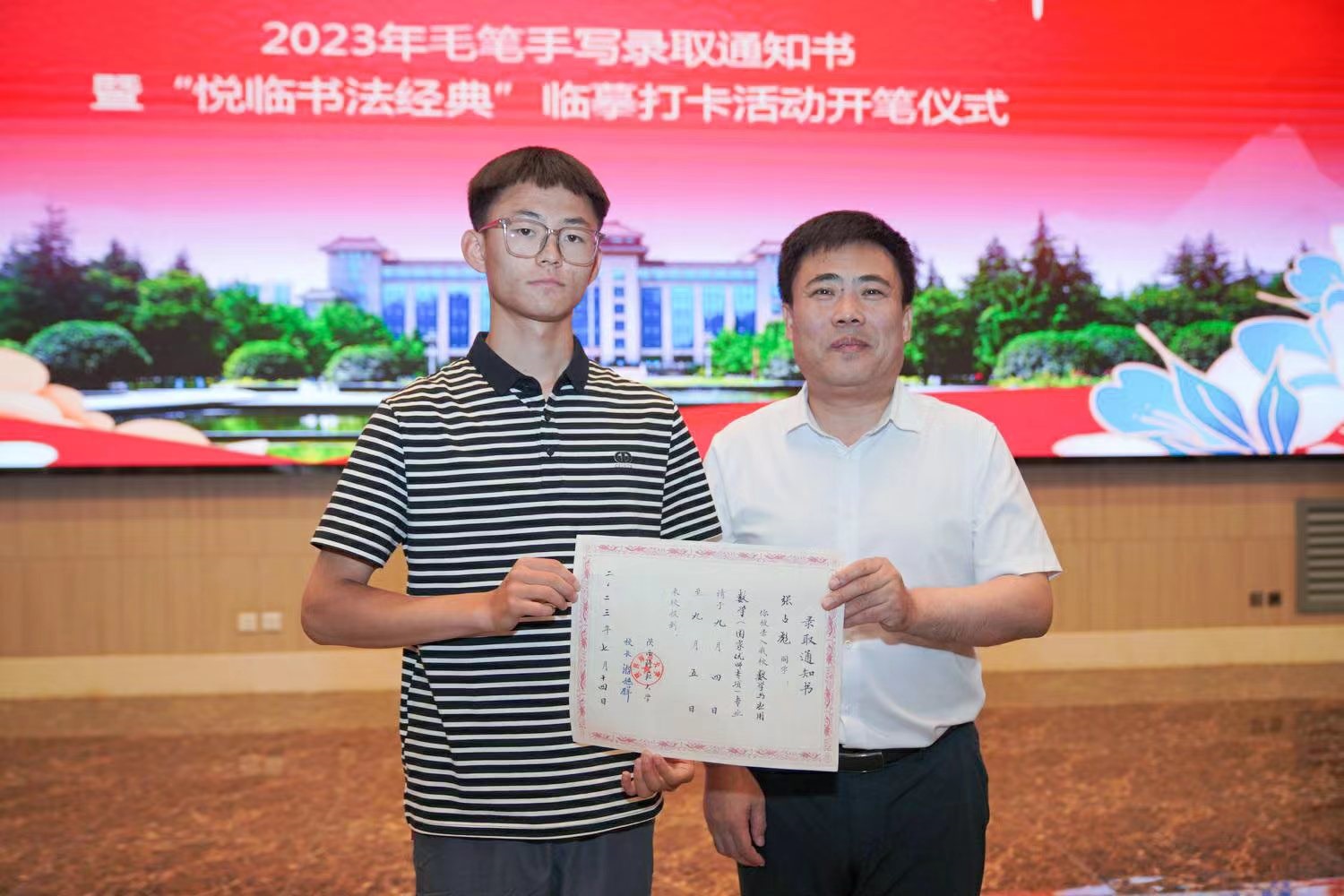 陜西師范大學(xué)黨委書(shū)記李忠軍為2023級(jí)新生代表張占彪同學(xué)發(fā)放錄取通知書(shū)。校方供圖