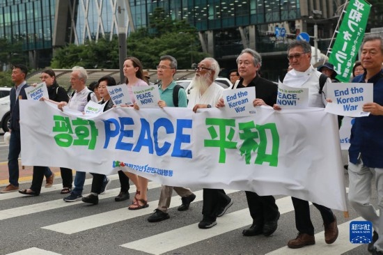 7月22日，在韓國首爾，人們手舉標(biāo)語參與反戰(zhàn)游行。新華社發(fā)（楊暢 攝）