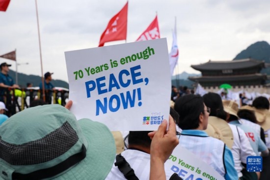 7月22日，在韓國首爾，人們手舉標(biāo)語參與反戰(zhàn)游行。新華社發(fā)（楊暢 攝）