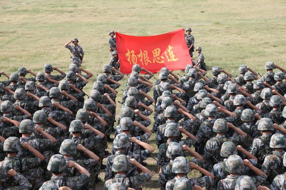 ↑“楊根思連”官兵執(zhí)行任務(wù)前向連旗宣誓（資料照片）。新華社發(fā)