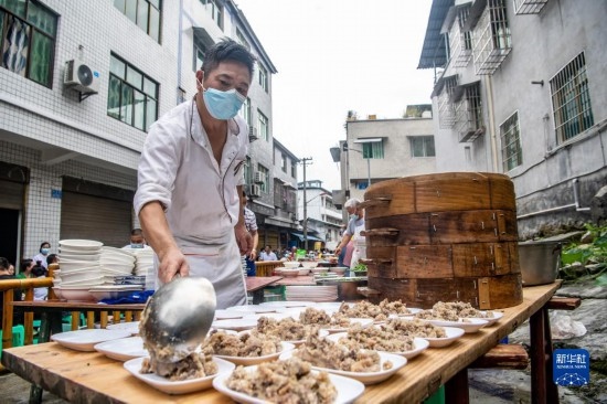 7月29日，在重慶市綦江區(qū)安穩(wěn)鎮(zhèn)，當?shù)鼐用裨凇懊缂曳蚬?jié)”上準備羊肉長桌宴。新華社記者 唐奕 攝