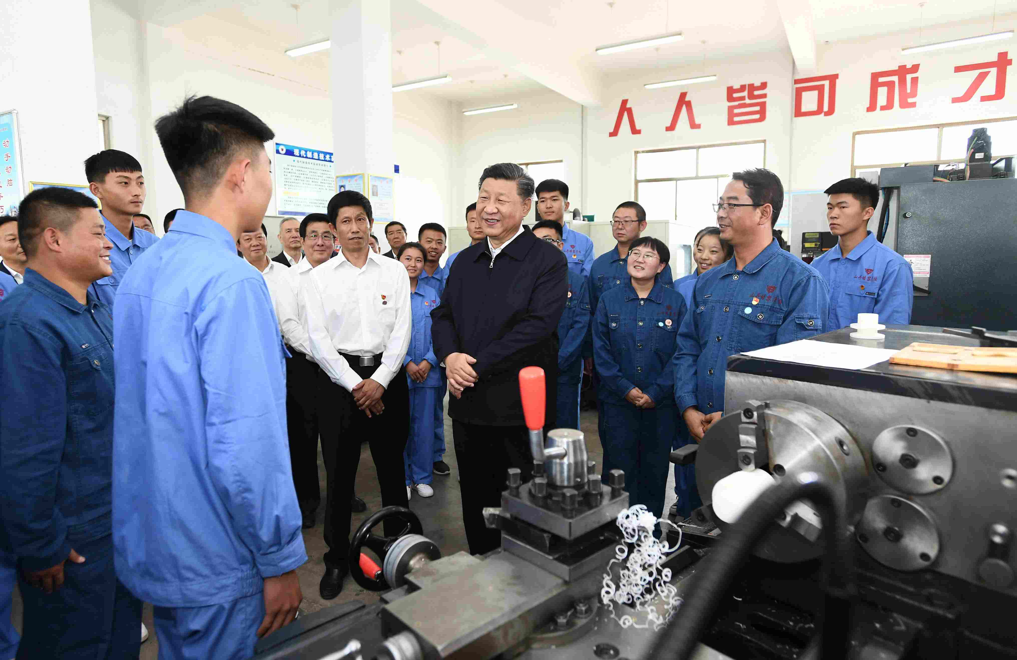 2019年8月20日，習(xí)近平在甘肅省張掖市山丹培黎學(xué)?，F(xiàn)代制造技術(shù)實(shí)訓(xùn)室，觀看職業(yè)技能實(shí)訓(xùn)，同師生親切交流。