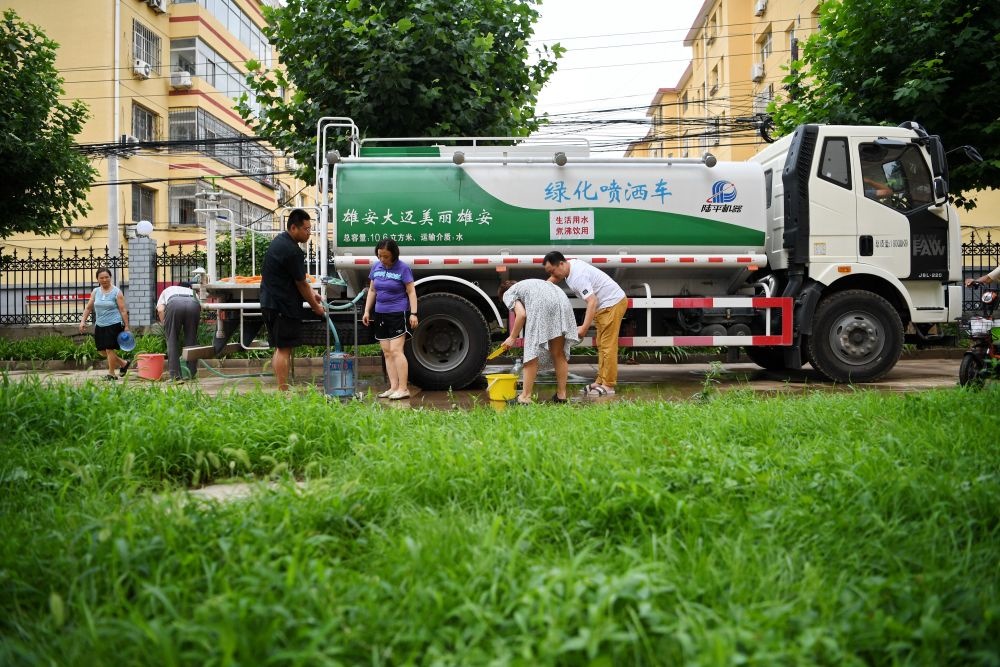 河北省涿州市新星小區(qū)居民從供水車?yán)锝铀?月4日攝）。新華社記者 牟宇 攝