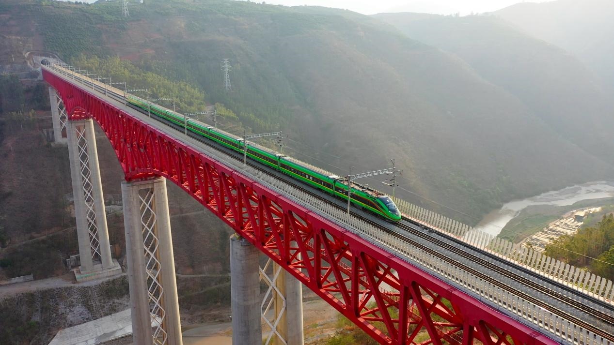 中老鐵路國際旅客列車在云南省境內(nèi)的元江特大橋上飛馳。姚巍攝
