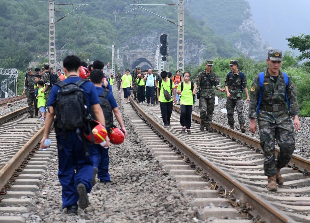 8月2日，部分滯留在北京市門頭溝山區(qū)受困列車的旅客，在救援人員幫助下前往轉運客車。新華社記者張晨霖 攝