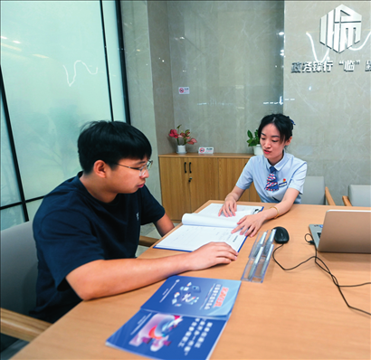 在杭州市臨安區(qū)政務(wù)服務(wù)中心的“為企服務(wù)中心”，黨員志愿者（右）解答企業(yè)主的疑問(wèn)（2023年7月7日攝）。徐昱攝/本刊