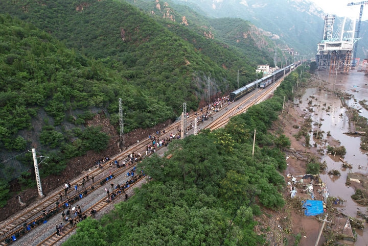 8月2日，受困列車(chē)旅客在救援人員幫助下徒步趕往轉(zhuǎn)運(yùn)客車(chē)（無(wú)人機(jī)照片）。新華社記者 張晨霖 攝