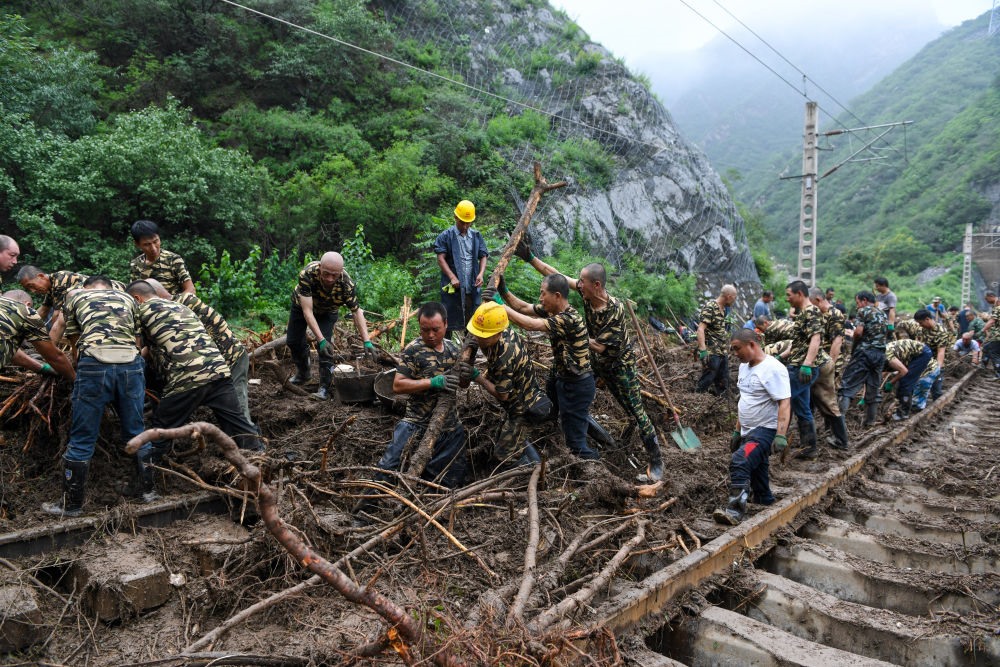 8月1日，在北京市門(mén)頭溝區(qū)水峪嘴村附近一段被阻斷的鐵路線上，中鐵六局工作人員在清理軌道上的雜物，全力恢復(fù)交通。新華社記者 鞠煥宗 攝