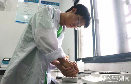 吳健筆在獼猴桃科技小院實(shí)驗室測量水果糖分。 人民網(wǎng)記者 劉賓攝