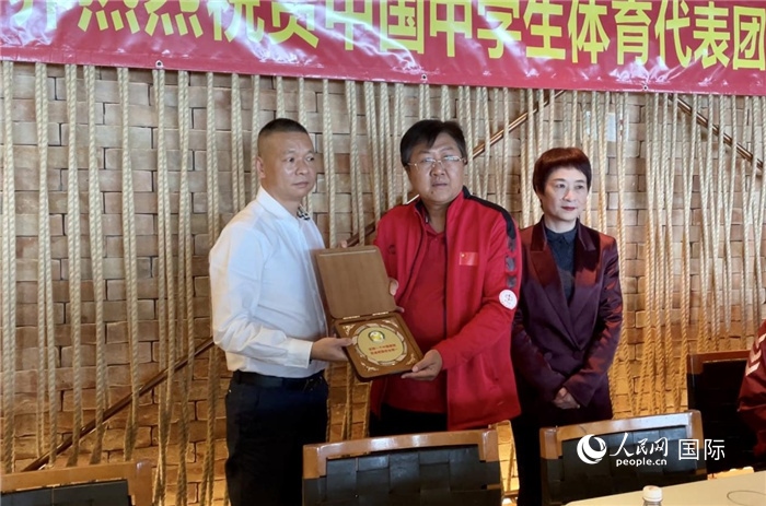巴西中國和平統(tǒng)一促進會會長王俊曉向中國中學(xué)生體育代表團團長劉立新贈送紀(jì)念品。人民網(wǎng)記者 宋亦然攝