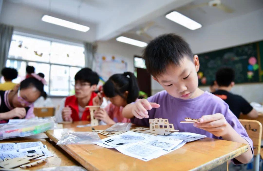 △今年7月，在浙江余姚市舜北小學(xué)暑托班內(nèi)，孩子們制作太陽能科學(xué)實驗裝置。
