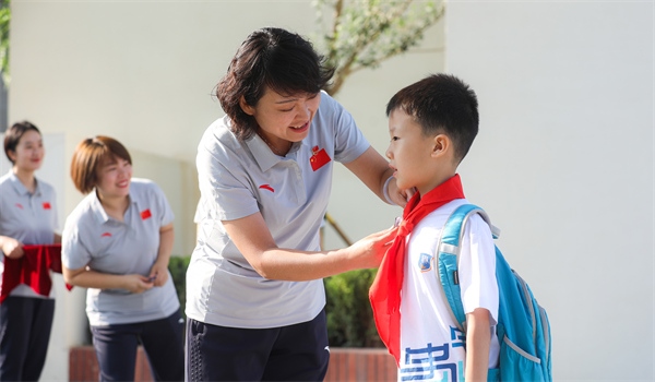 8月30日，雄安史家胡同小學(xué)學(xué)生體驗(yàn)學(xué)校生活。老師為學(xué)生佩戴?；?。