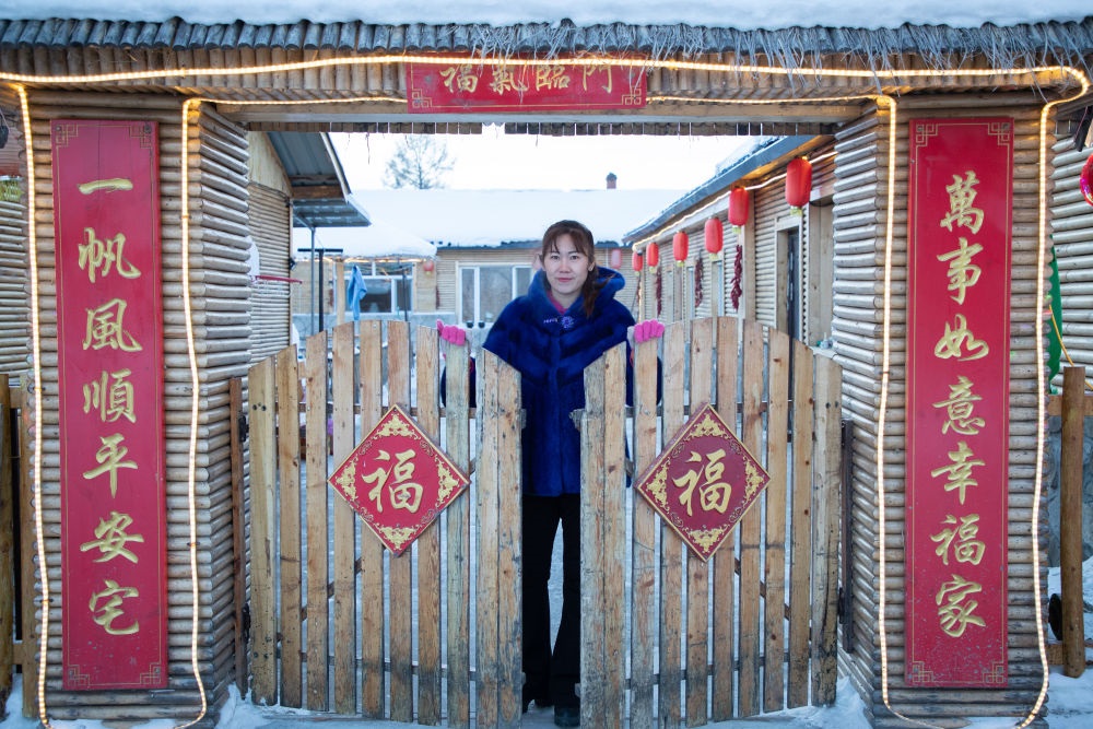 北極村民宿經(jīng)營者史瑞娟在門前迎候入住的游客（2023年1月7日攝）。