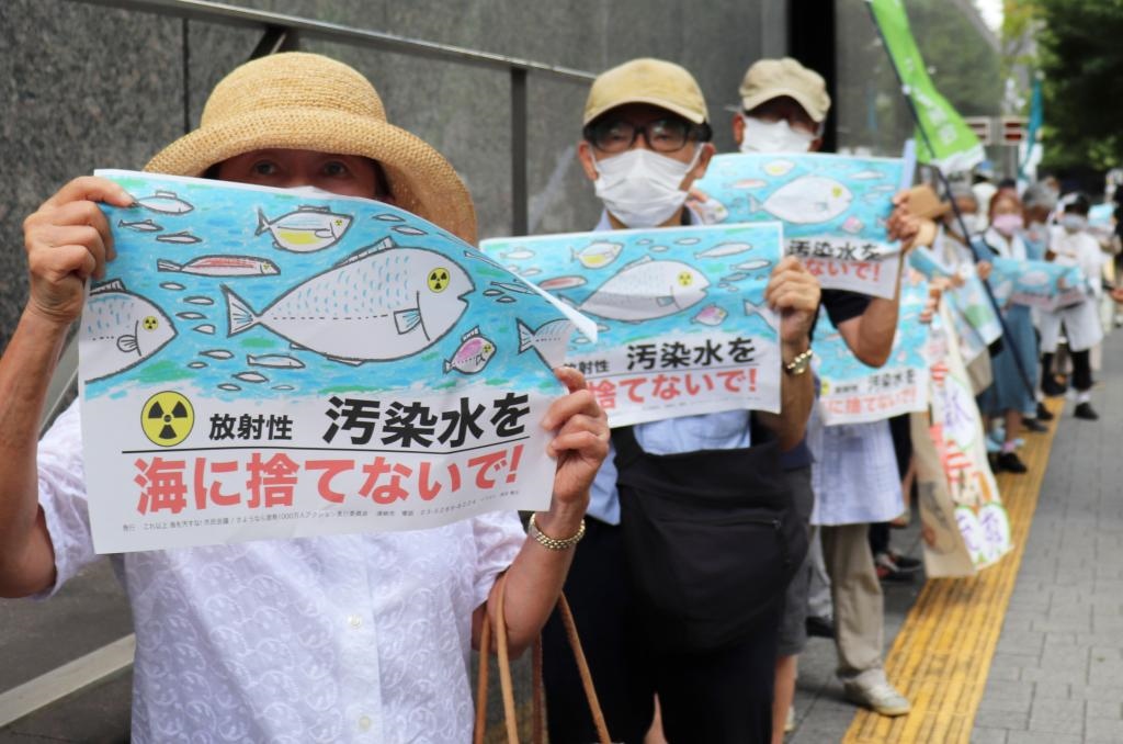 8月24日，日本民眾手持“不要將污染水扔進(jìn)大?！钡葮?biāo)語在東京電力公司總部前集會，抗議日本政府和東電公司無視民意啟動核污染水排海。新華社記者楊光攝
