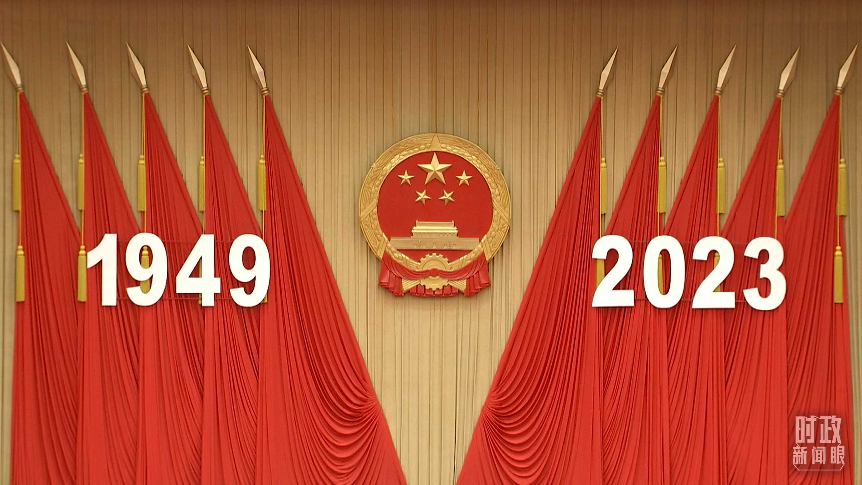△人民大會(huì)堂宴會(huì)廳內(nèi)，主席臺(tái)上方高懸著莊嚴(yán)的國(guó)徽，“1949－2023”大字年號(hào)在鮮艷的紅旗映襯下格外醒目。