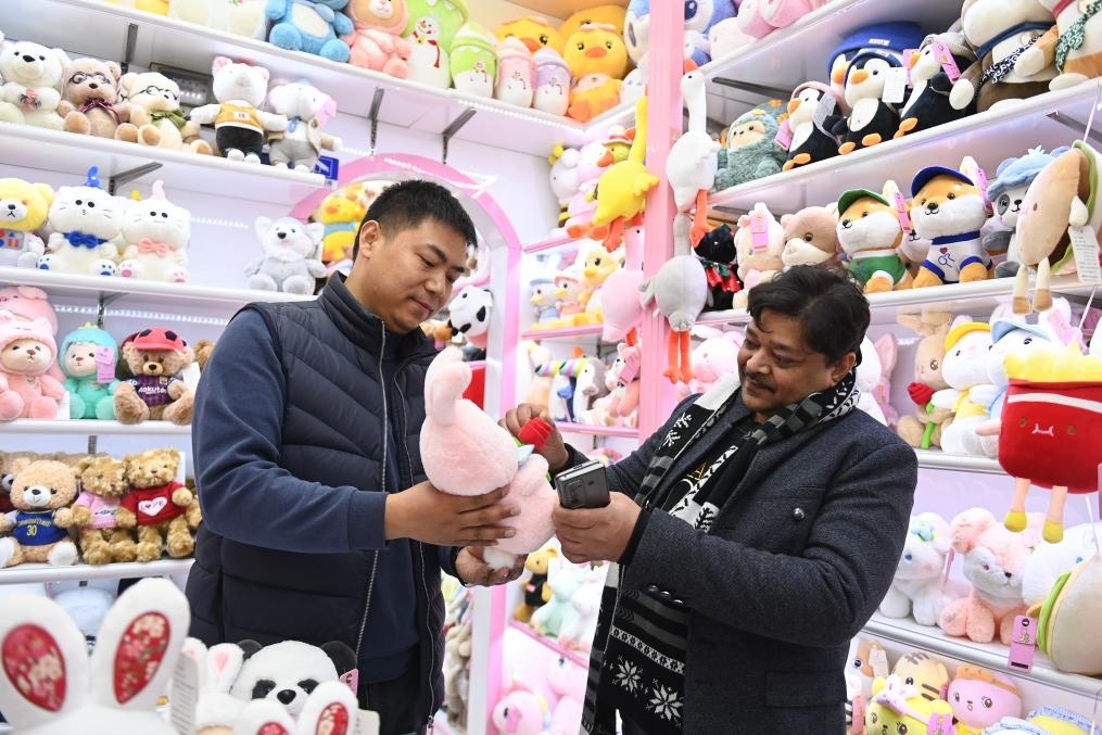 2023年2月2日，來(lái)自印度的客商（右）在義烏國(guó)際商貿(mào)城的一家玩具店鋪內(nèi)選購(gòu)商品。新華社記者 黃宗治 攝