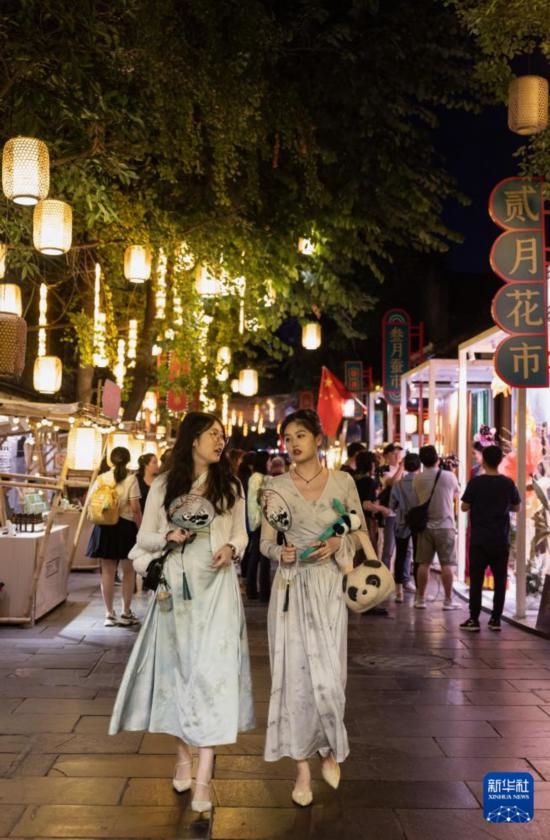 在成都寬窄巷子，兩位來(lái)自安徽的游客在新“十二月市”街區(qū)游覽（9月29日攝）。