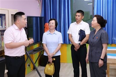 圖③：“小公民法律課堂”開(kāi)講前，全國(guó)人大代表殷其龍（右二）、重慶市人大代表李自玲（左二）聽(tīng)取楊家坪中學(xué)負(fù)責(zé)人關(guān)于未成年人思想教育工作情況的介紹。