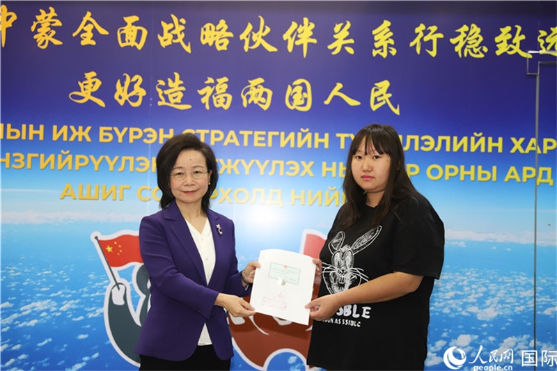 11月10日，沈敏娟大使向蒙古國(guó)公民尼亞姆庫(kù)（右）頒發(fā)最后一份領(lǐng)事認(rèn)證書(shū)。人民網(wǎng)記者 霍文攝