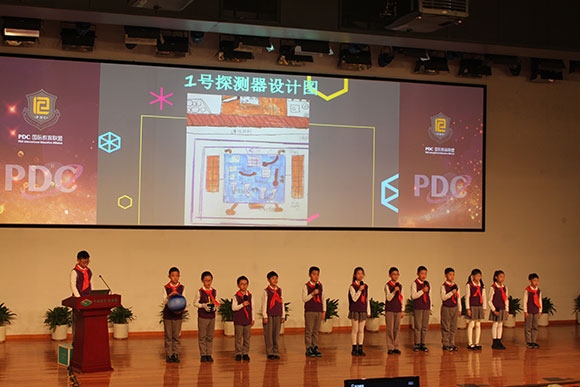 北京呼家樓中心小學的學生們展示PDC項目“新行星移民計劃探索衛(wèi)星設計”。