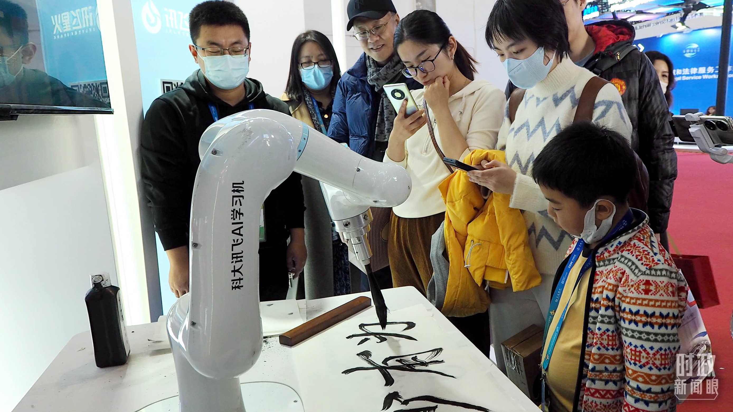 △觀眾在首屆鏈博會上體驗AI書法機器人。