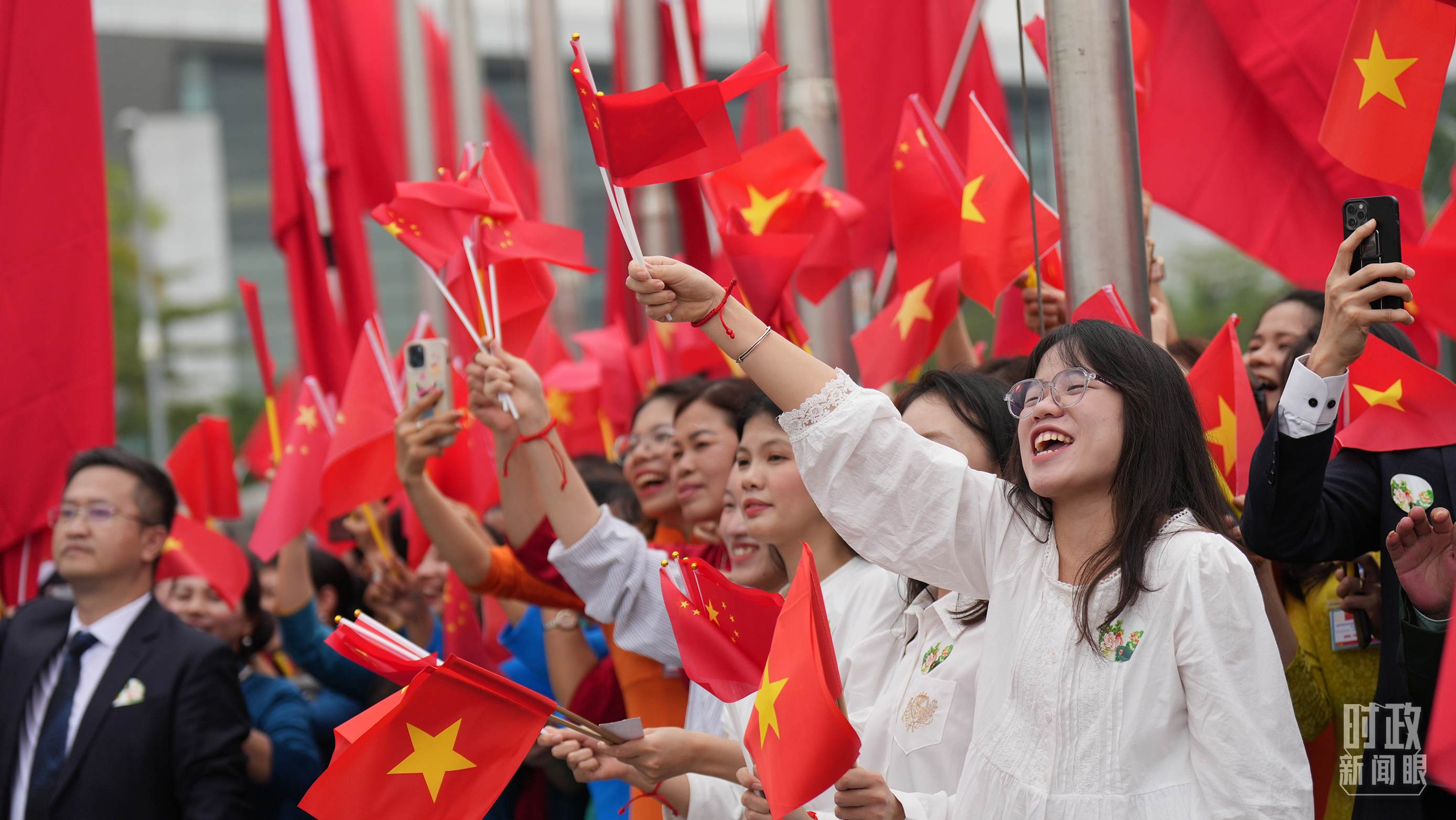 △人們揮舞兩國旗幟歡迎習(xí)近平訪越。（總臺國廣記者李晉拍攝）