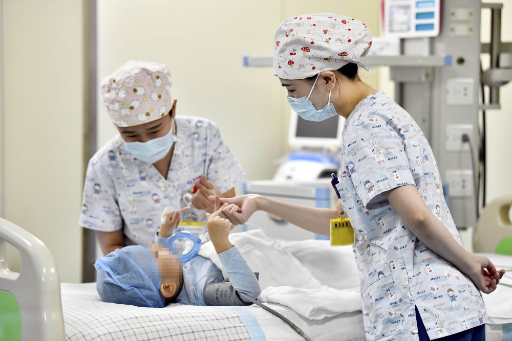 在山東省棗莊市婦幼保健院兒童ICU病房，醫(yī)護(hù)人員為完成靶向治療藥物諾西那生鈉的4歲脊髓性肌萎縮癥患兒加油鼓勁（2022年1月1日攝）。諾西那生鈉注射液是我國首個獲批治療脊髓性肌萎縮癥的進(jìn)口藥物，2019年進(jìn)入中國市場時，每針價格近70萬元。在2021年國家醫(yī)保目錄藥品談判中，以3.3萬元每針的價格進(jìn)入新版醫(yī)保藥品目錄。新華社記者 郭緒雷 攝