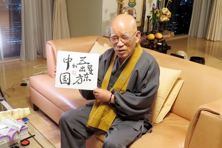 小島康譽展示自己書寫的“五星出東方利中國”。視頻截圖